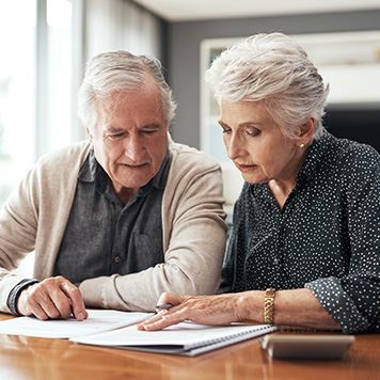 elderly couple looking at papers